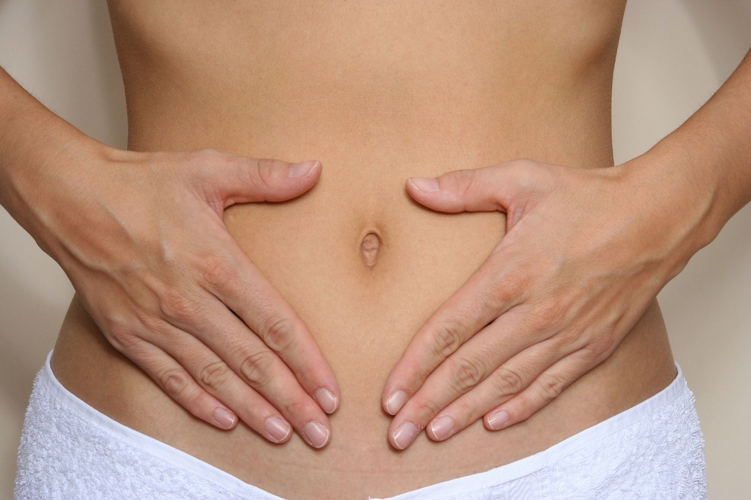 frauen bauch mit der hand in herzform um den nabel hashifit darmflora 16 Plus
